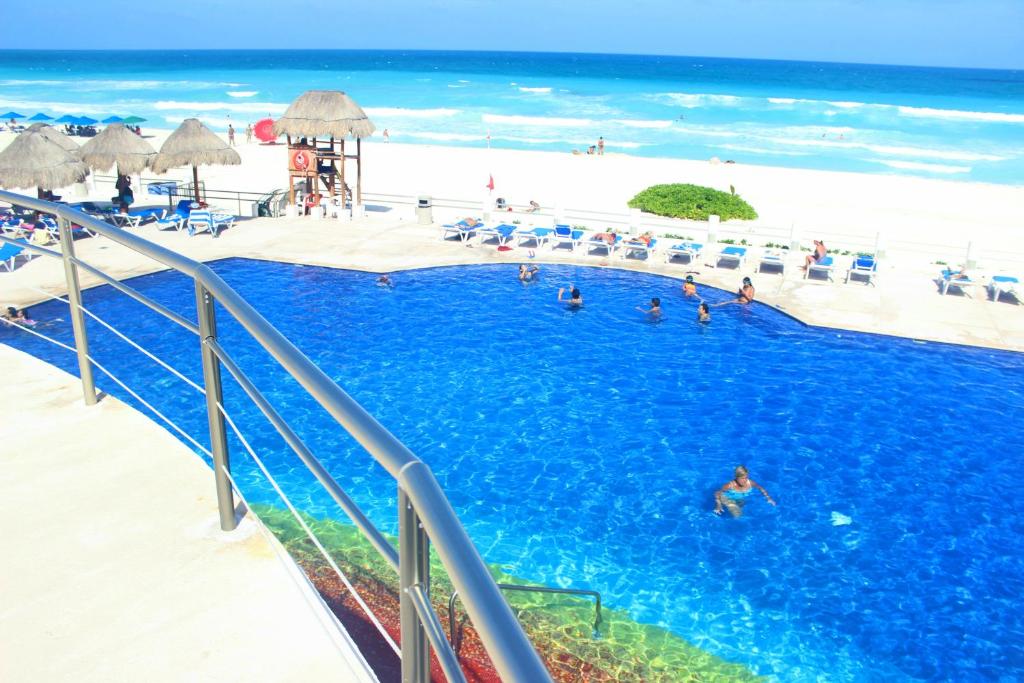 una piscina en la playa con gente en el agua en Villas Marlin 2, en Cancún