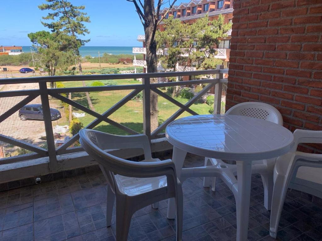 een tafel en stoelen op een balkon met uitzicht op de oceaan bij Complejo Playa Palace The Residence in Costa del Este