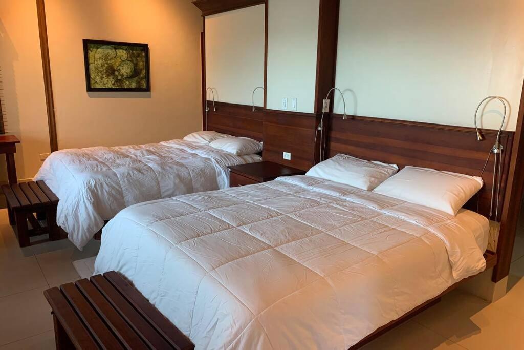 ein Hotelzimmer mit zwei Betten und einem Spiegel in der Unterkunft Luxurious Round Cay in Cayos Cochinos