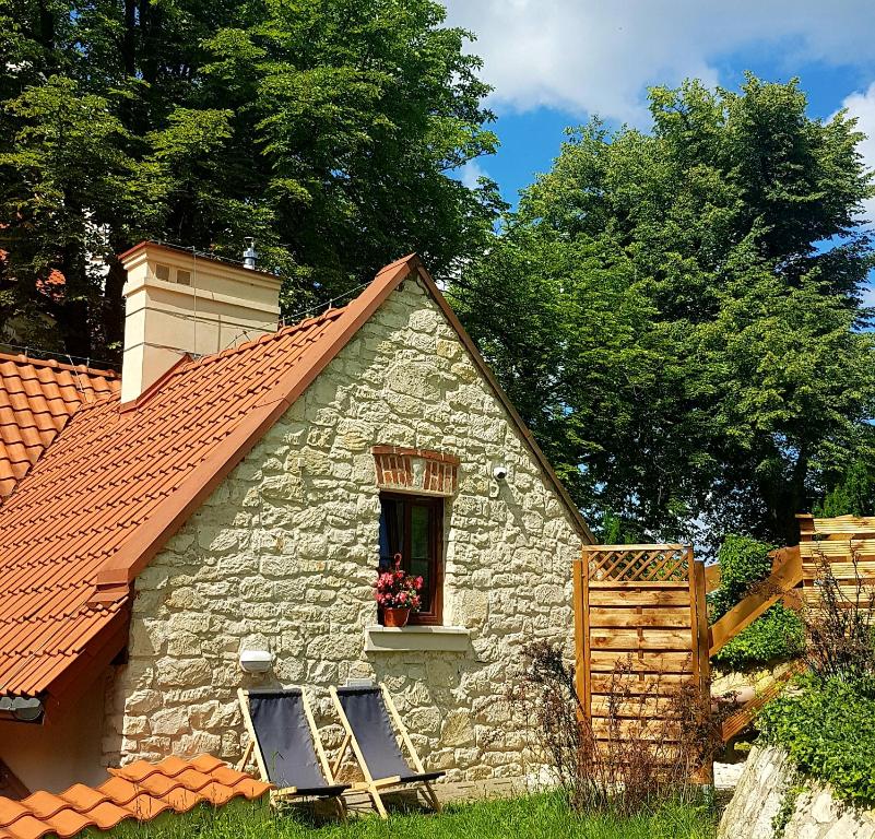 une maison en pierre avec deux chaises et une fenêtre dans l'établissement Serce miasta, à Kazimierz Dolny
