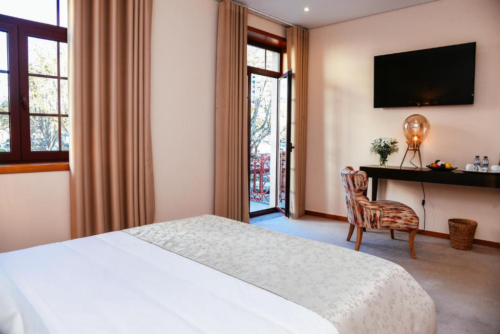 una camera d'albergo con letto e scrivania di Santo Thyrso Hotel a Santo Tirso