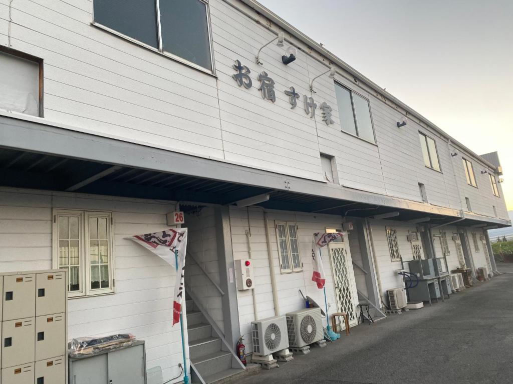 een wit gebouw met een bord aan de zijkant bij Oyado Sukeya in Saijo