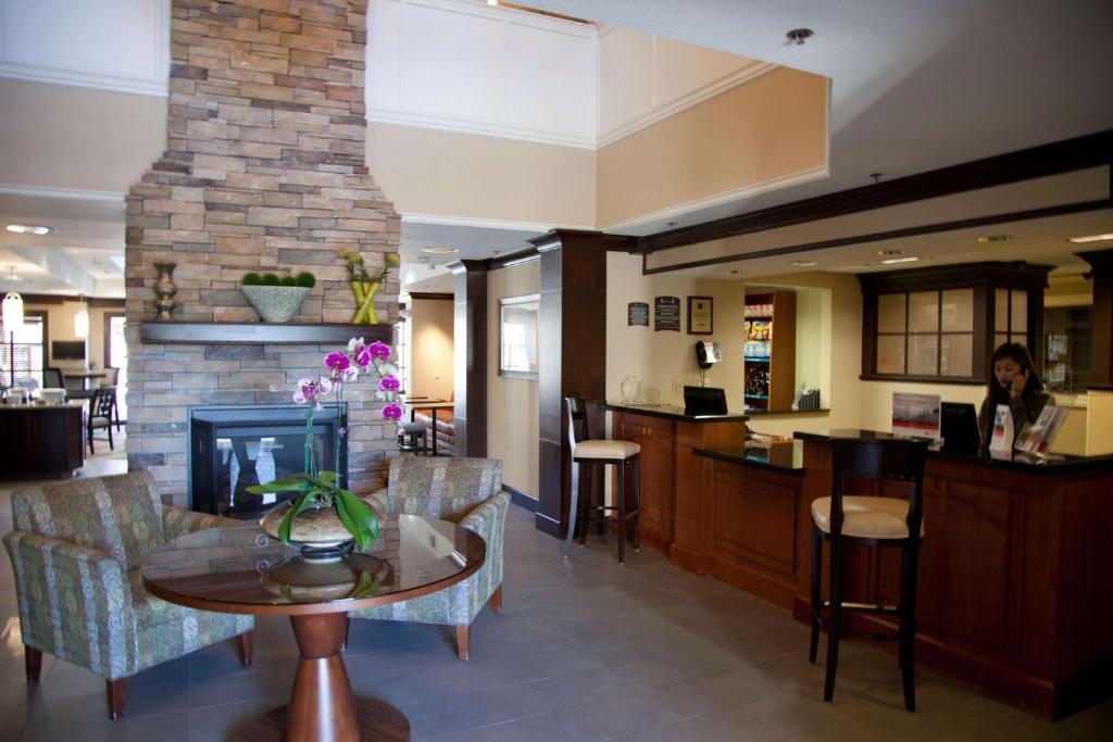 a living room with a table and a fireplace at Sonesta ES Suites Sunnyvale in Sunnyvale
