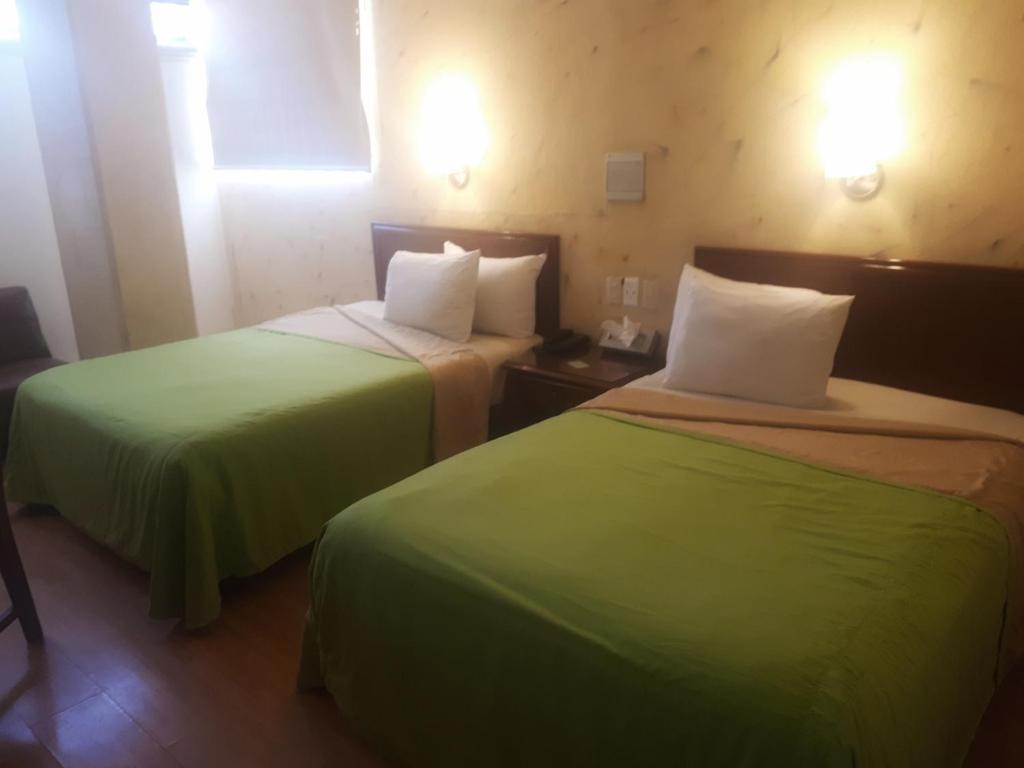 Postel nebo postele na pokoji v ubytování Hotel Enterprise Inn Plaza