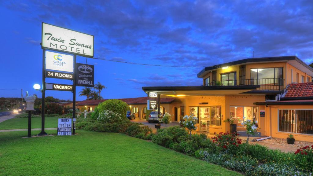 un hotel con un cartel frente a un edificio en Twin Swans Motel en Inverell