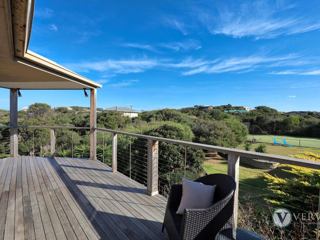 a deck with a chair and a view of a field at Sea Ranch in Rye