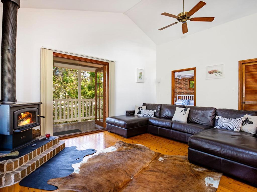 Callala BayEagles Point I Water Views I Pet Friendly的带沙发和壁炉的客厅