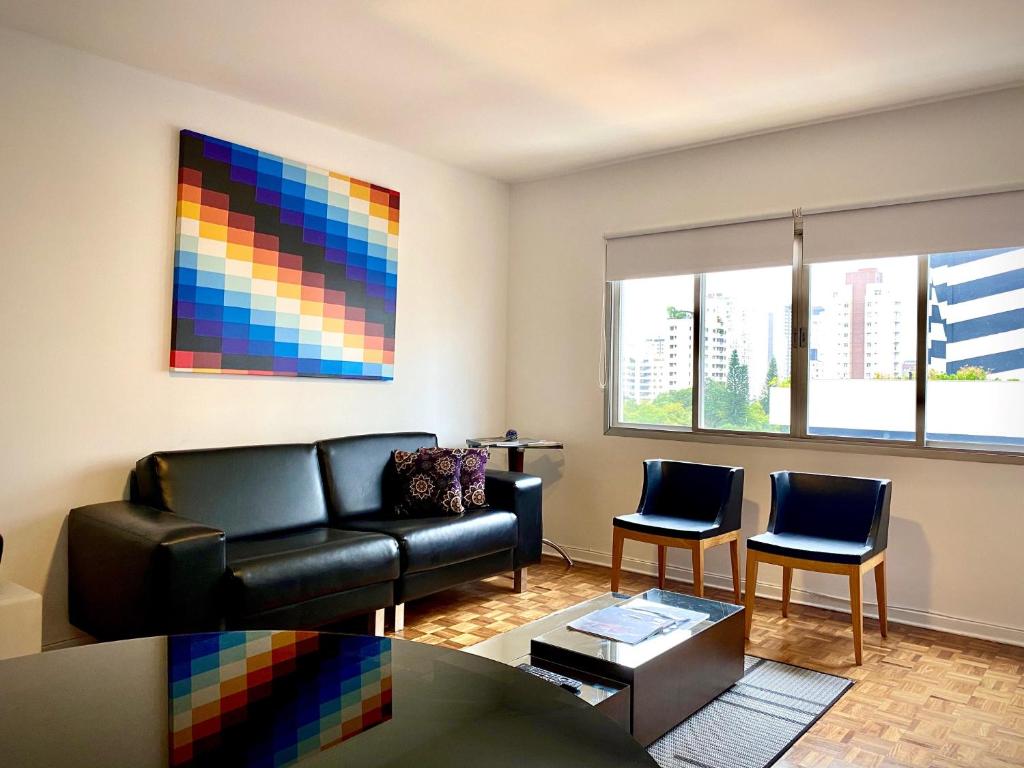 sala de estar con sofá y 2 sillas en Vila Olímpia Colors, en São Paulo