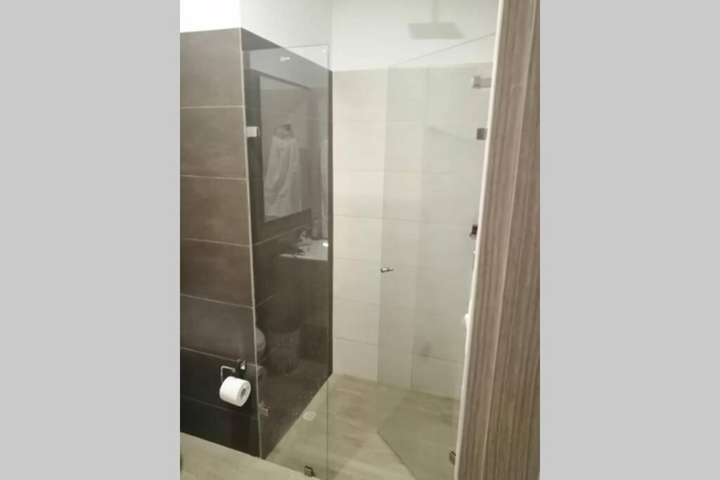 a bathroom with a shower with a glass door at APARTAMENTO TORRES DE BARLOVENTO in Ibagué