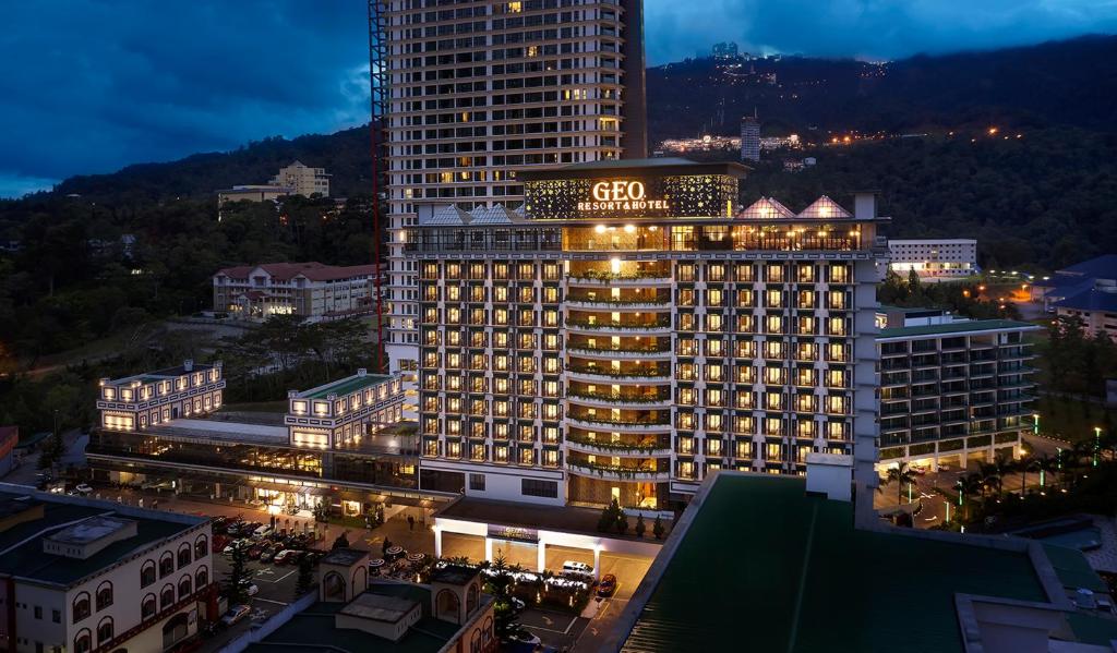 un grand bâtiment avec un panneau la nuit dans l'établissement GEO RESORT & HOTEL, à Genting Highlands