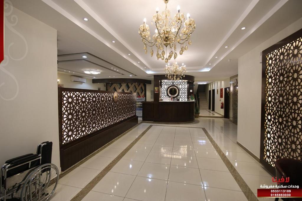 a lobby with a chandelier in the middle of a building at لافينا حائل للاجنحة الفندقية in Hail