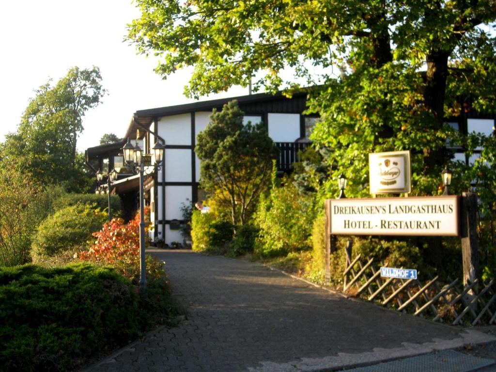 ein Schild vor einem Gebäude mit einem Schild in der Unterkunft Dreikausens Landgasthaus Wildhof in Cleeberg