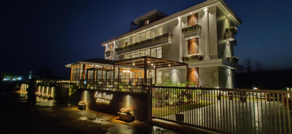 a building with a fence in front of it at night at Leela Resort in Mahabaleshwar