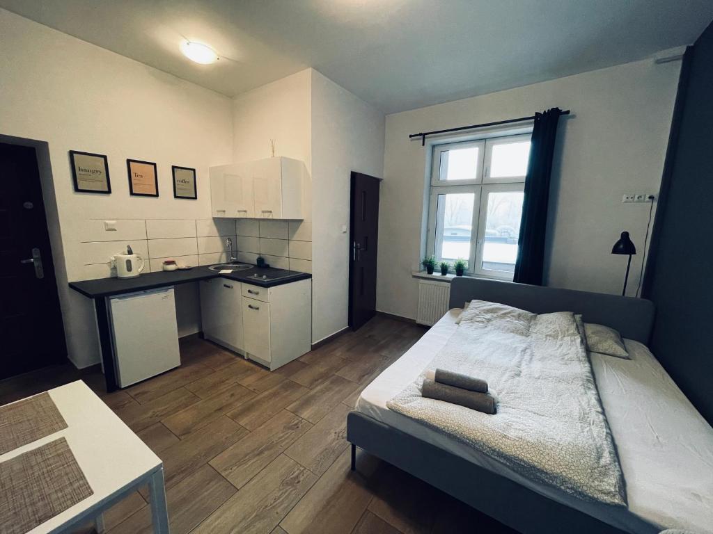 ein kleines Schlafzimmer mit einem Bett und einer Küche in der Unterkunft eM Apartment 6 in Kattowitz