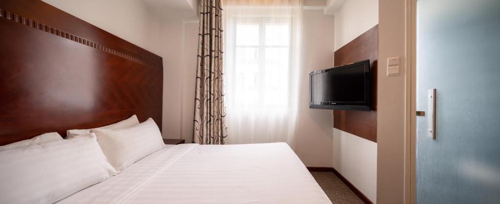 a bedroom with a bed with a flat screen tv at The Quay Hotel West Coast in Singapore