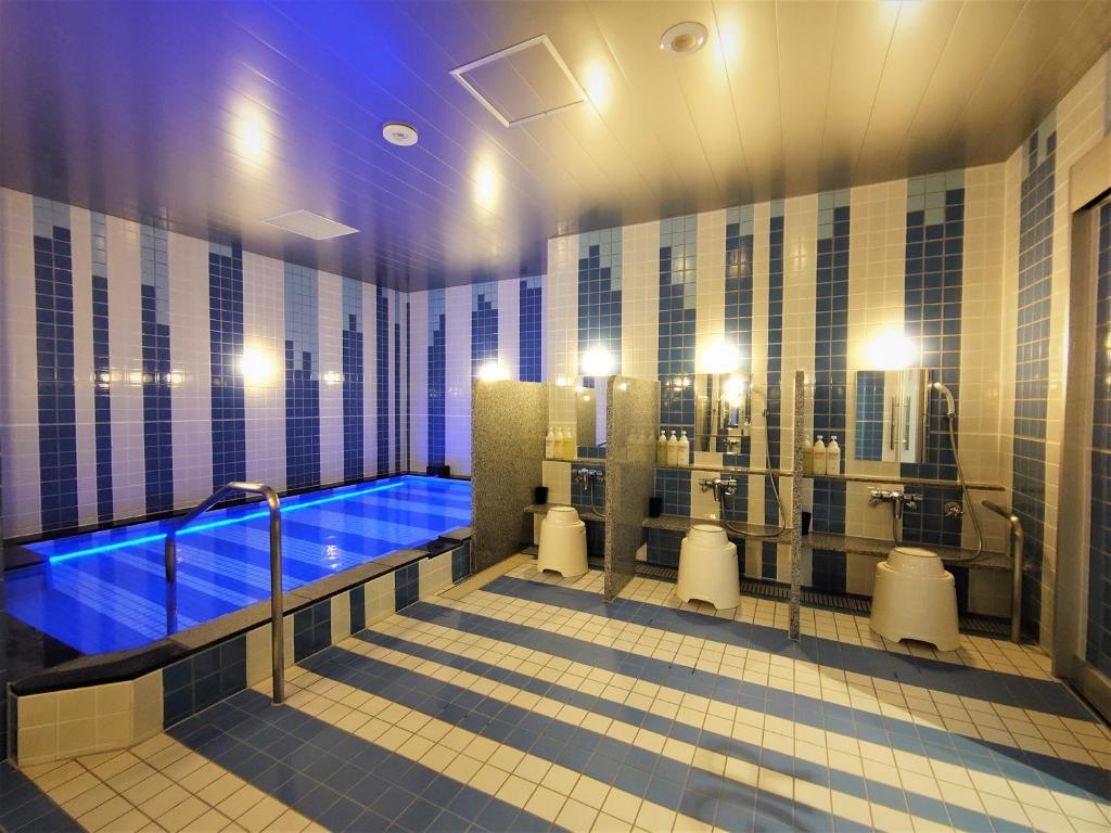 a large bathroom with a blue tub in it at Green Rich Hotel Nagoya Nishiki (Artificial hot spring Futamata Yunohana) in Nagoya