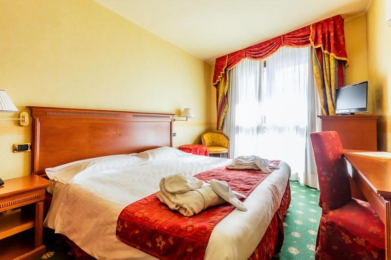 Postel nebo postele na pokoji v ubytování Hotel Cristallo