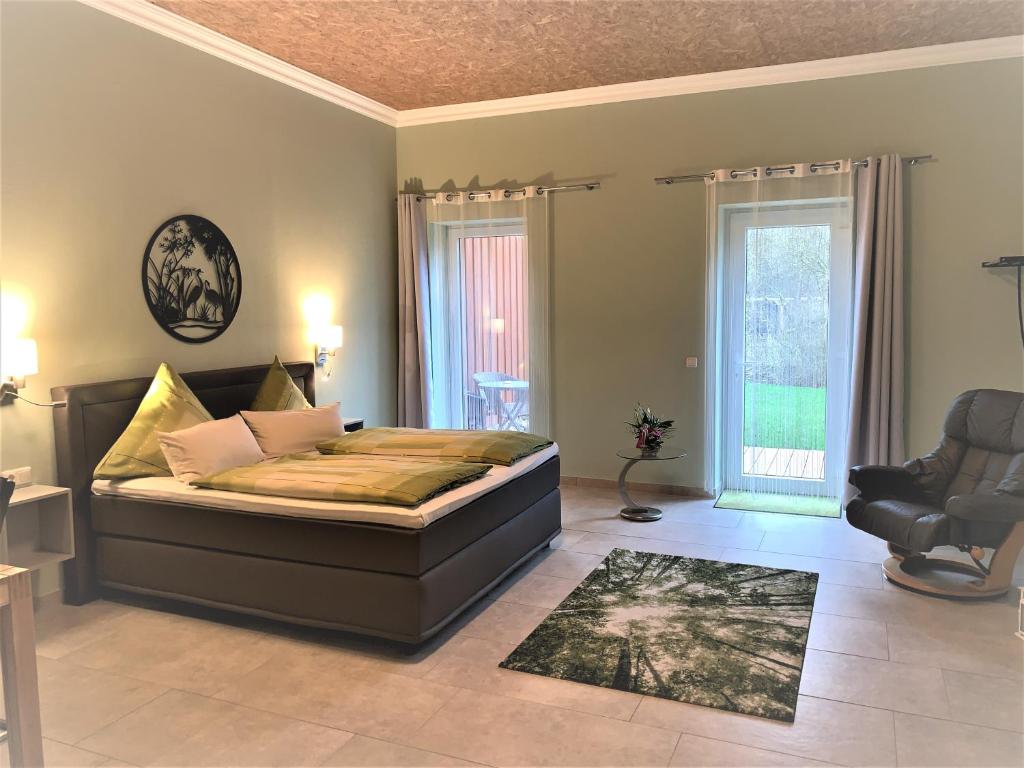 a bedroom with a bed and a chair at Gästezimmer & Appartement Elskop in Elskop