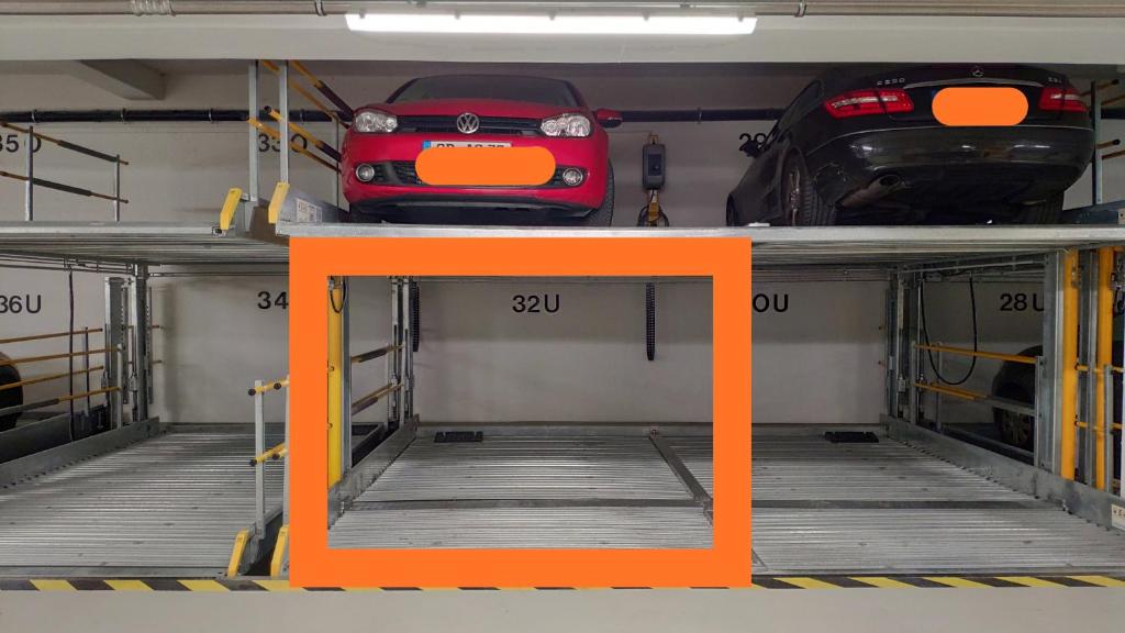 a garage with two cars and a car on a shelf at Apartment "SUN" in Friedrichshafen