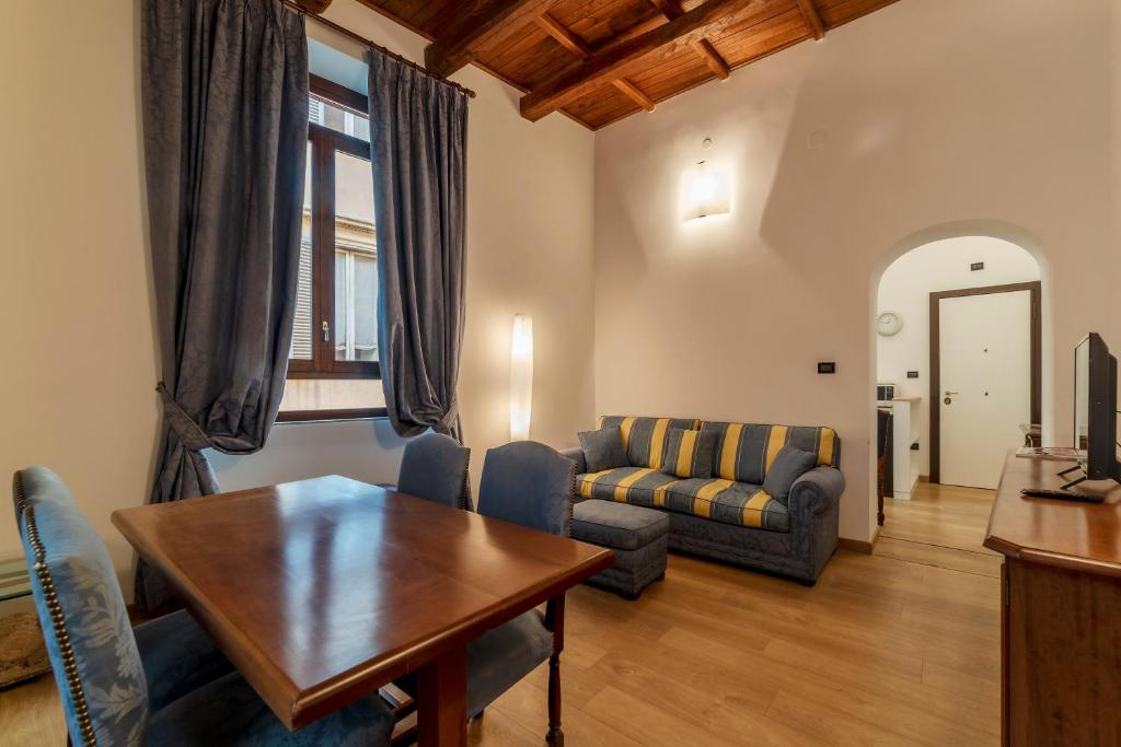 a living room with a table and a couch at Piazza di Spagna Elegant Apartment in Rome