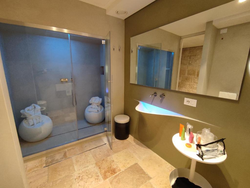 La salle de bains est pourvue d'une douche et d'un lavabo. dans l'établissement Antico Mondo Rooms & Suites, à Polignano a Mare