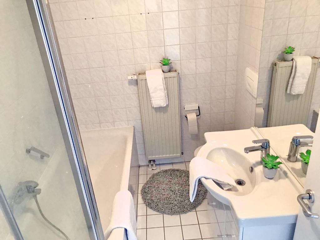 La salle de bains est pourvue de toilettes, d'un lavabo et d'une douche. dans l'établissement SUNNYHOME Monteurwohnungen und Apartments nahe Regensburg, à Nittendorf