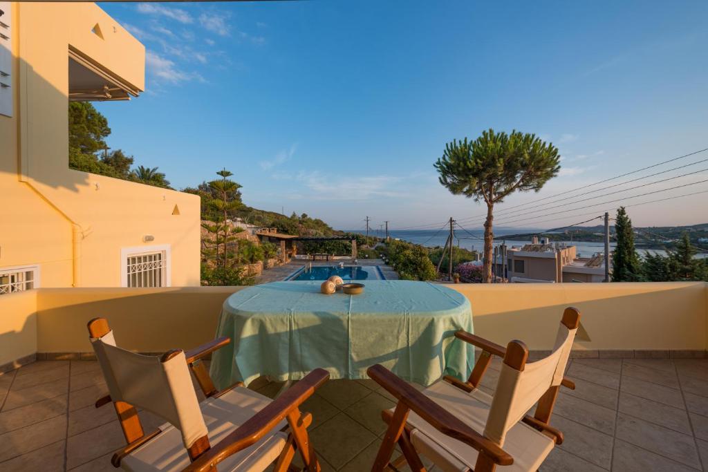 a table and chairs on a patio with a pool at Villa Barite in Sounio