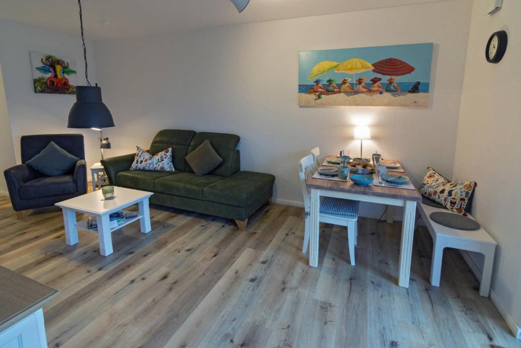 ein Wohnzimmer mit einer Couch und einem Tisch in der Unterkunft Südwester in Dornumersiel