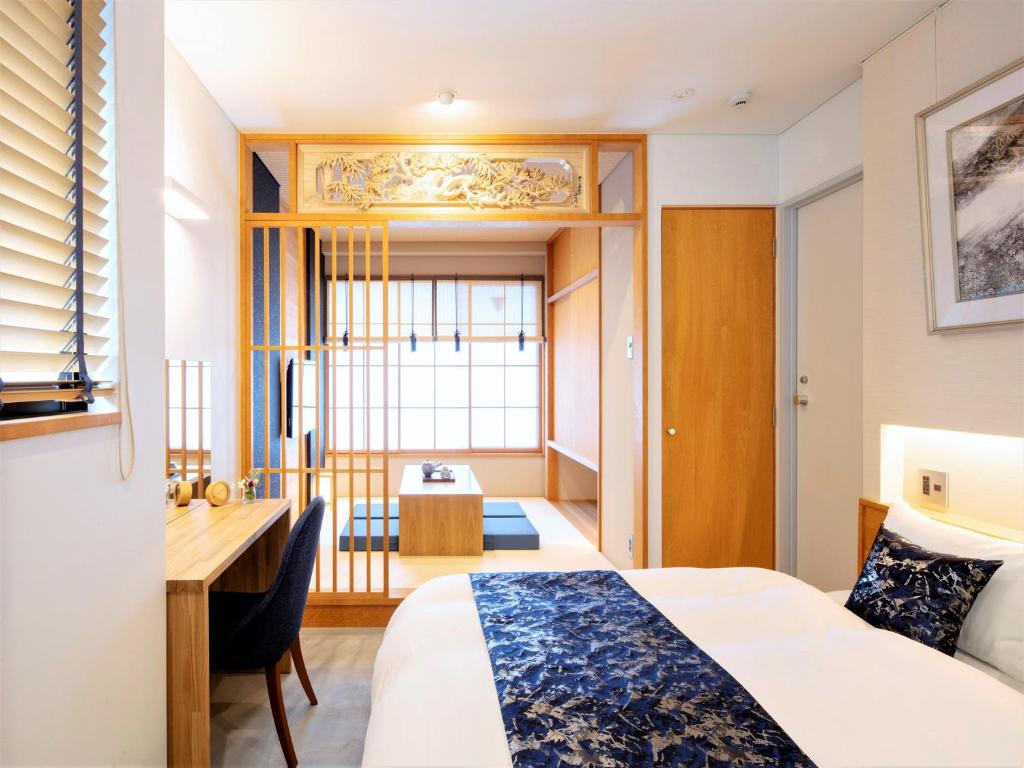 una camera d'albergo con un letto e una scrivania di Tanakaya Kyoto Karasuma a Kyoto