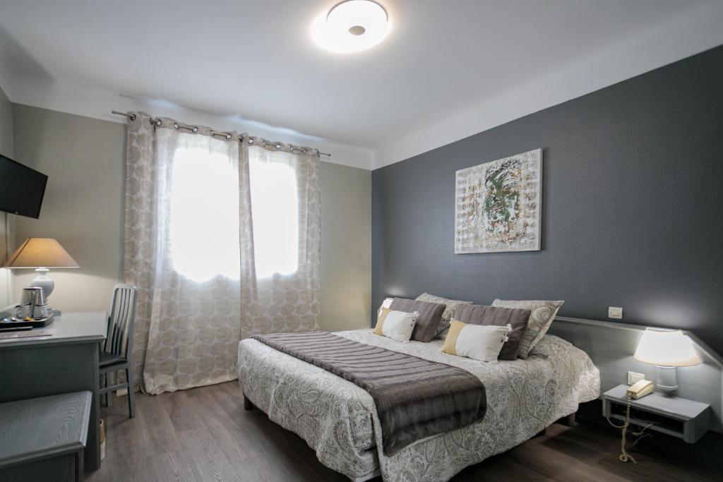 a bedroom with a large bed and a window at Hôtel Spunta Di Mare in Ajaccio