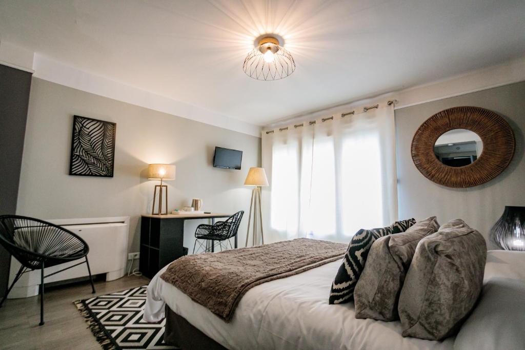 a bedroom with a bed and a window and a desk at Hôtel Spunta Di Mare in Ajaccio