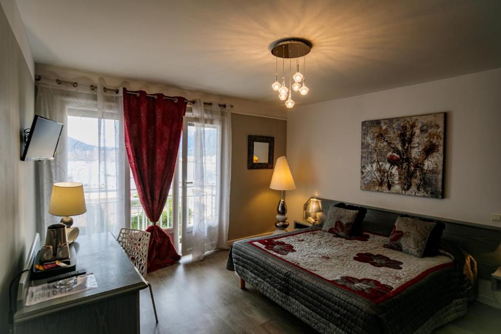 a bedroom with a bed and a large window at Hôtel Spunta Di Mare in Ajaccio