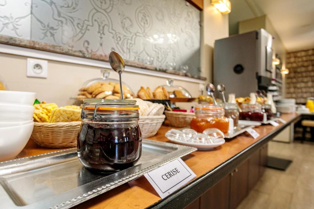 a buffet line with jam and baskets of bread at Hôtel Spunta Di Mare in Ajaccio