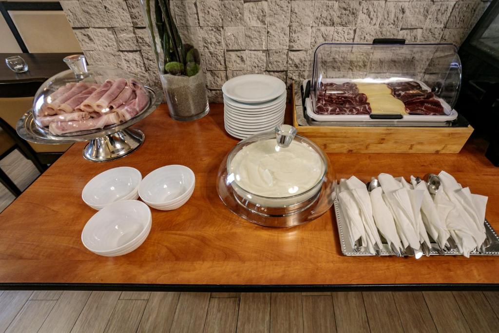 a table with plates and dishes and a tray of food at Hôtel Spunta Di Mare in Ajaccio