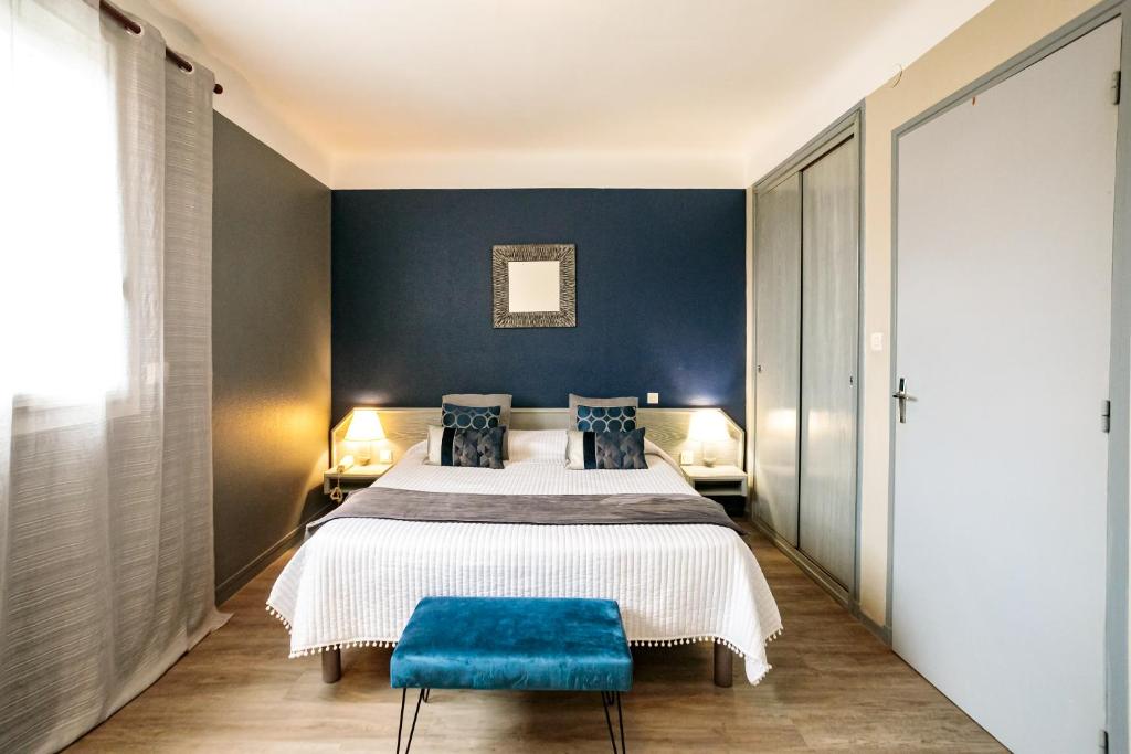 a bedroom with a bed and a blue stool at Hôtel Spunta Di Mare in Ajaccio