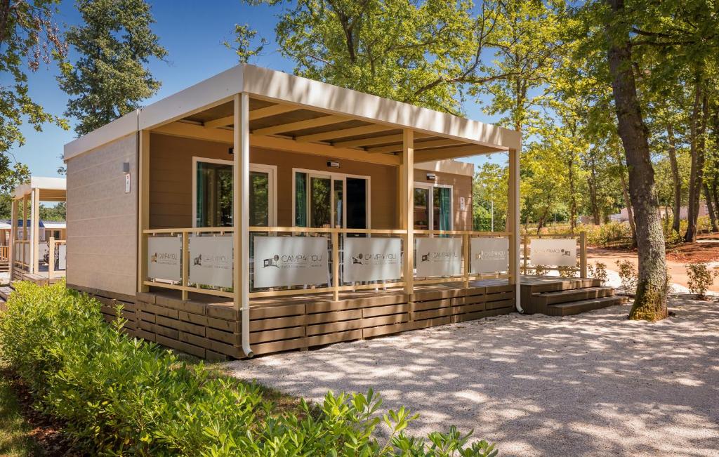 a modular house with a porch in a park at Mobile Homes Premium Relax Park Umag by Camp4You in Umag