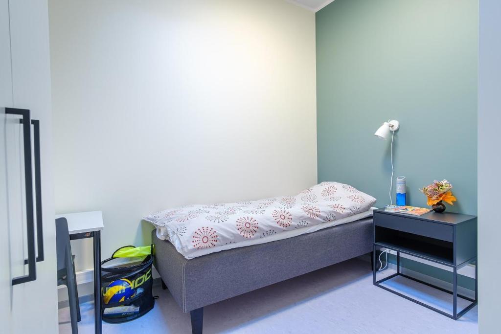 Cette petite chambre comprend un lit et une table de nuit. dans l'établissement Märjamaa spordihoone, à Märjamaa