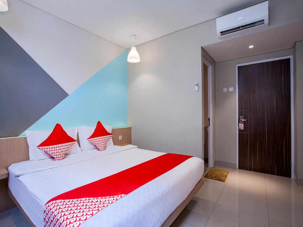 a bedroom with a large bed with red pillows at SUPER OYO Flagship 101 Apple Platinum in Jakarta