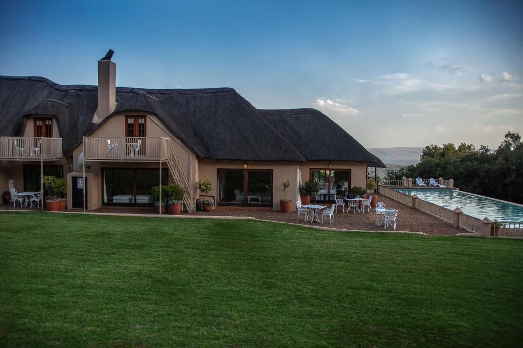 a house with a large yard with a swimming pool at Steynshoop Mountain Lodge (Hotel) in Hekpoort