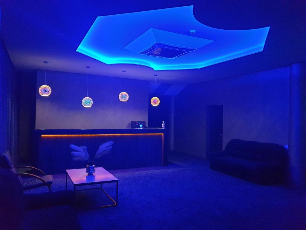 Habitación azul con sofá y mesa en LEX Trend Hotel en Irpin'
