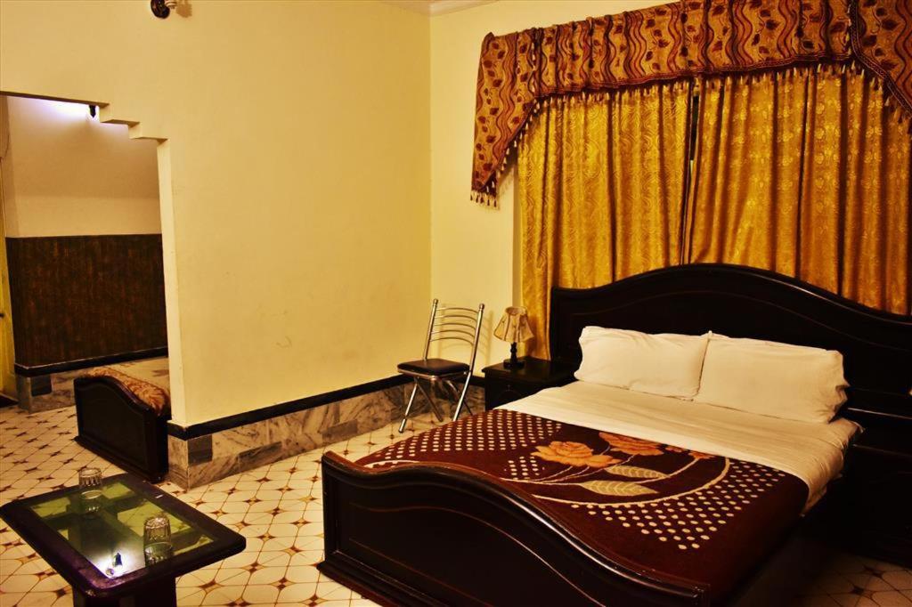 - une chambre avec un grand lit et une fenêtre dans l'établissement Suvastu Resort, à Swat