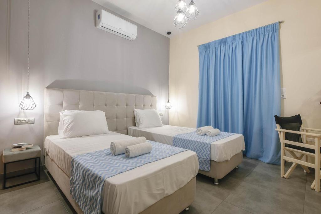 a bedroom with two beds and a blue curtain at Barcode Studios in Laganas