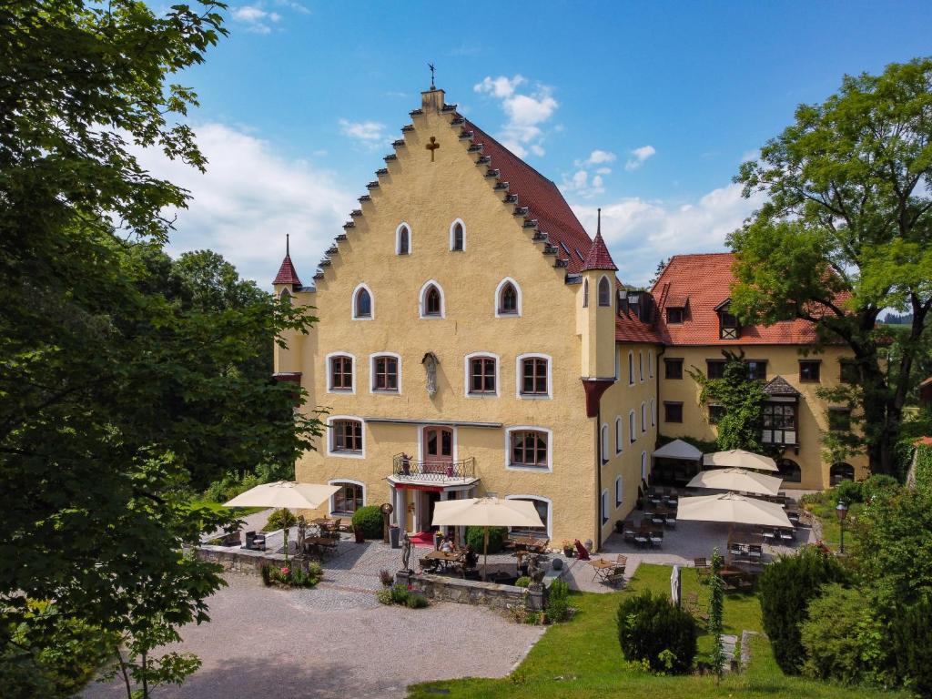 un gran edificio amarillo con techo puntiagudo en Schloss zu Hopferau, en Hopferau