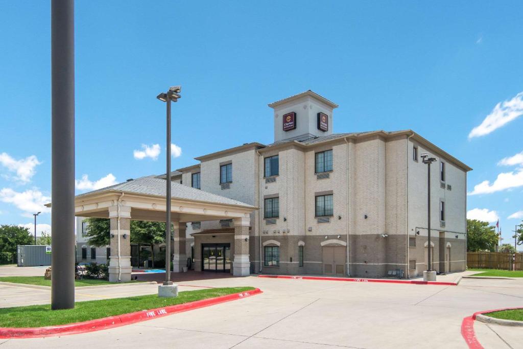 ein Gebäude mit einem Uhrturm darüber in der Unterkunft Clarion Inn & Suites Weatherford South in Weatherford