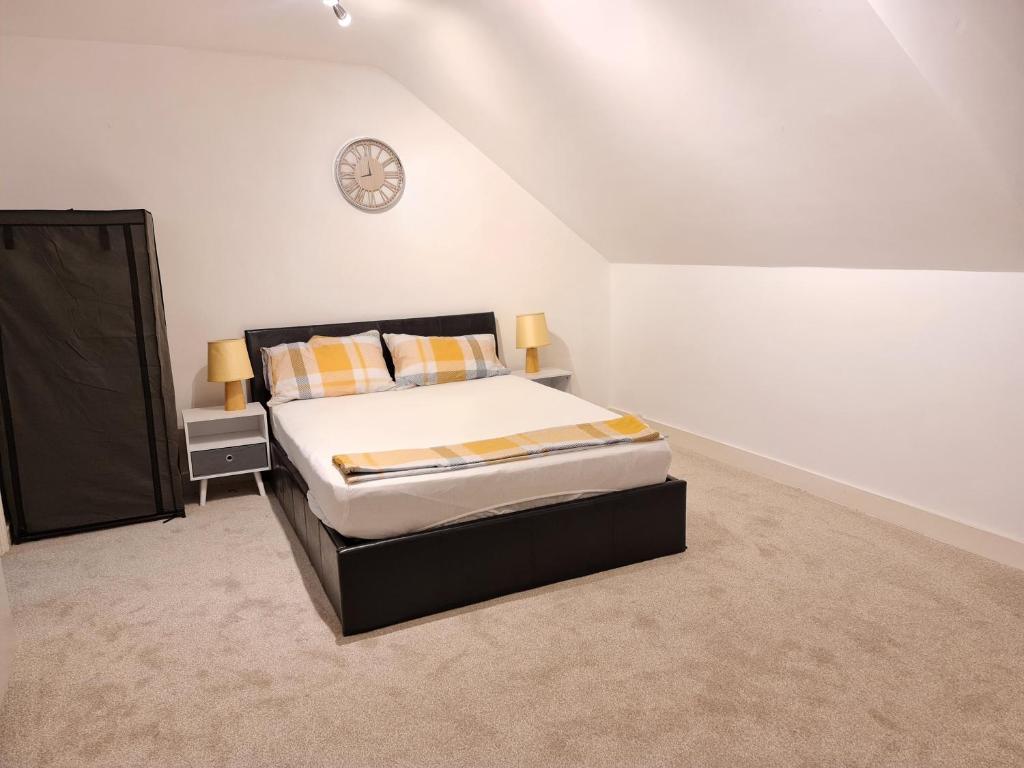 a bedroom with a bed and a clock on the wall at Grace Apartments - Living Spring 1 in Ashford