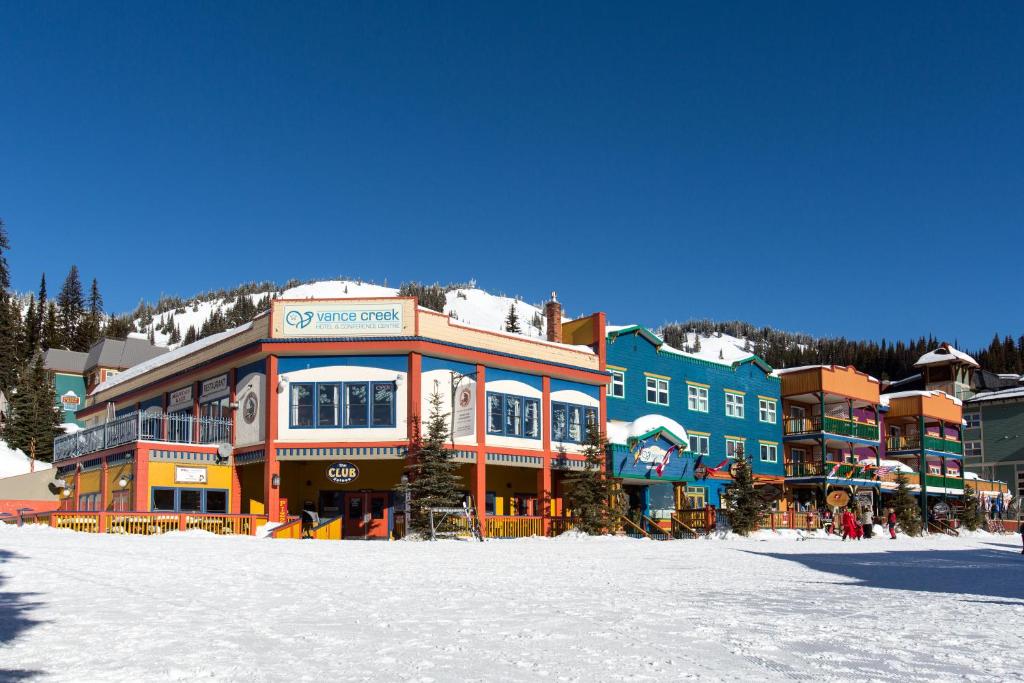 un edificio en la nieve frente a una montaña en The Vance Creek Hotel & Conference Centre, en Silver Star