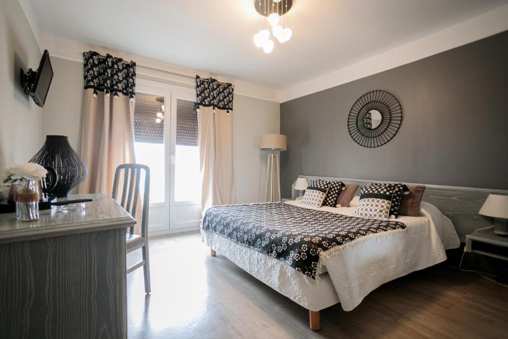 a bedroom with a bed and a table and a mirror at Hôtel Spunta Di Mare in Ajaccio