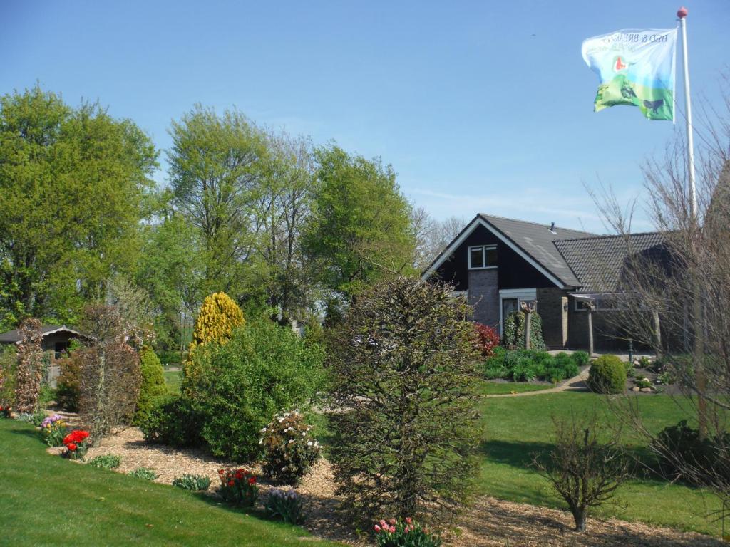a house with a flag flying in the yard at B&B De Kandelaar in Biddinghuizen