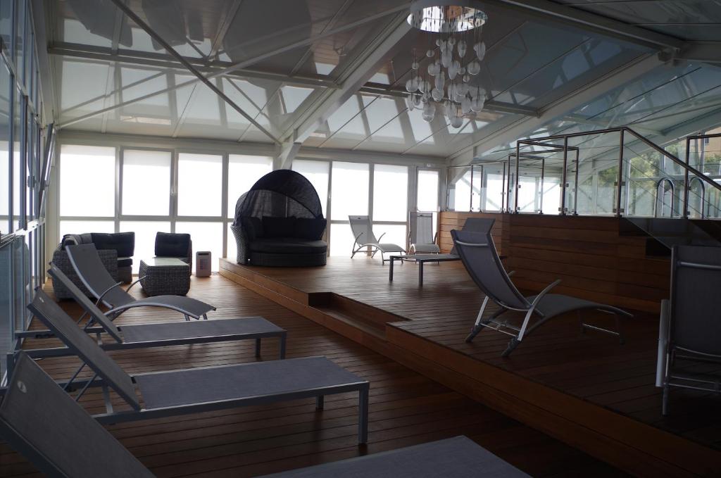 a large room with chairs and tables and windows at Hôtel Spunta Di Mare in Ajaccio