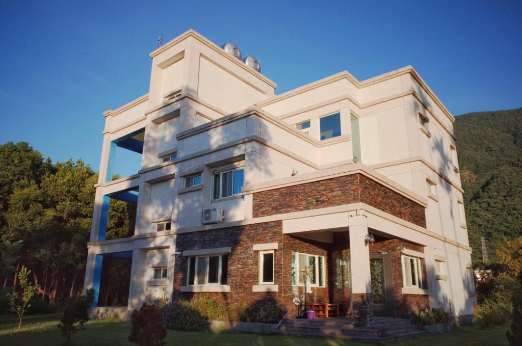 un grand bâtiment blanc au sommet d'une colline dans l'établissement ShiGuo Homestay, à Xiulin